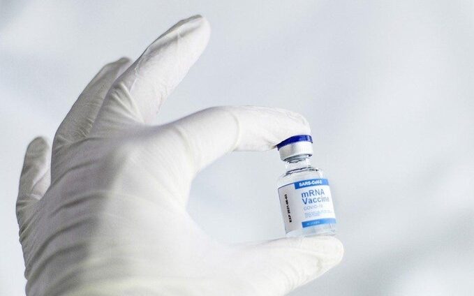 Relevance of Patient Registries Today Doctor holding vial of vaccine